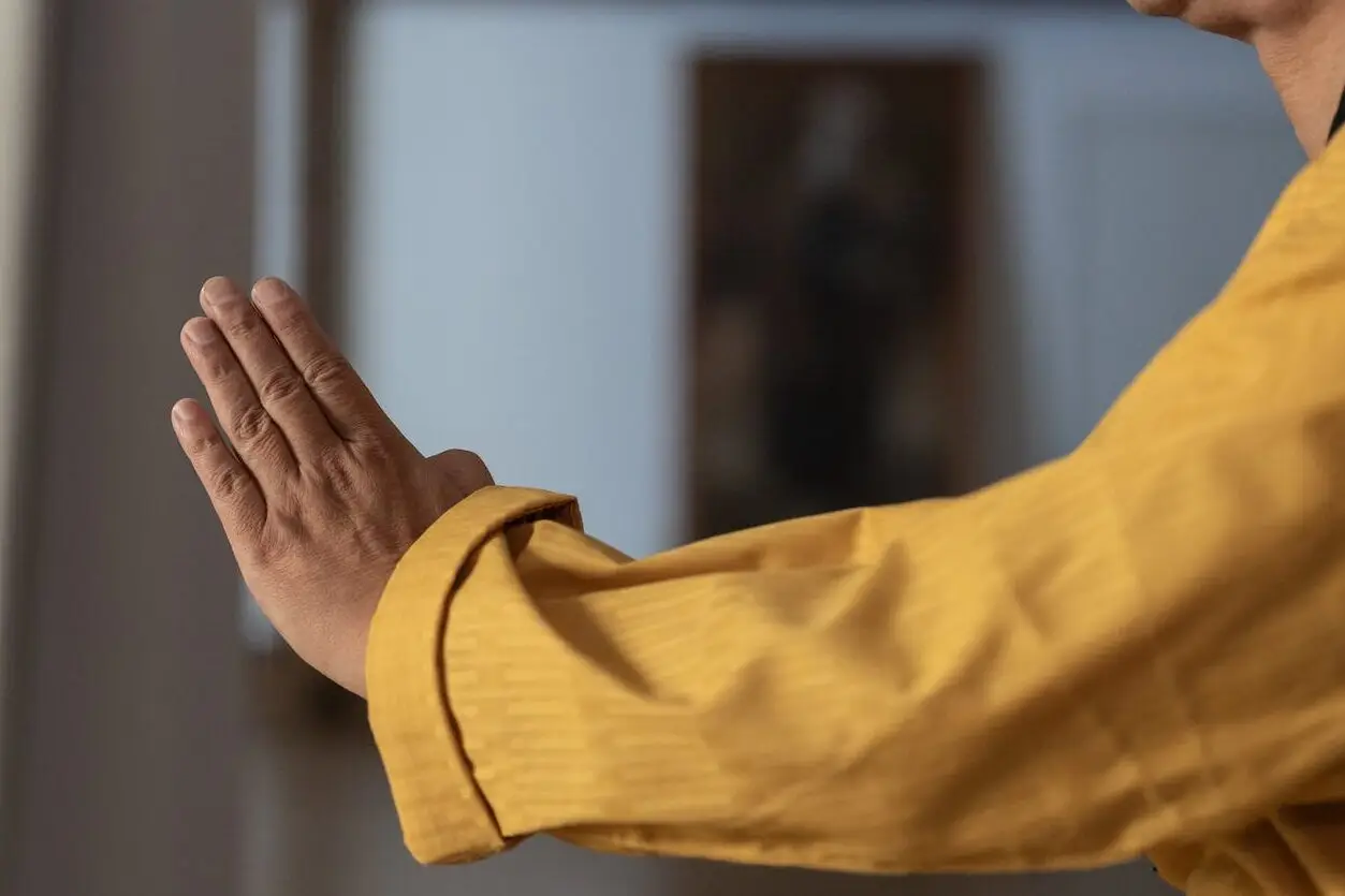 a man in mustard long sleeves shirt stretching his arm
